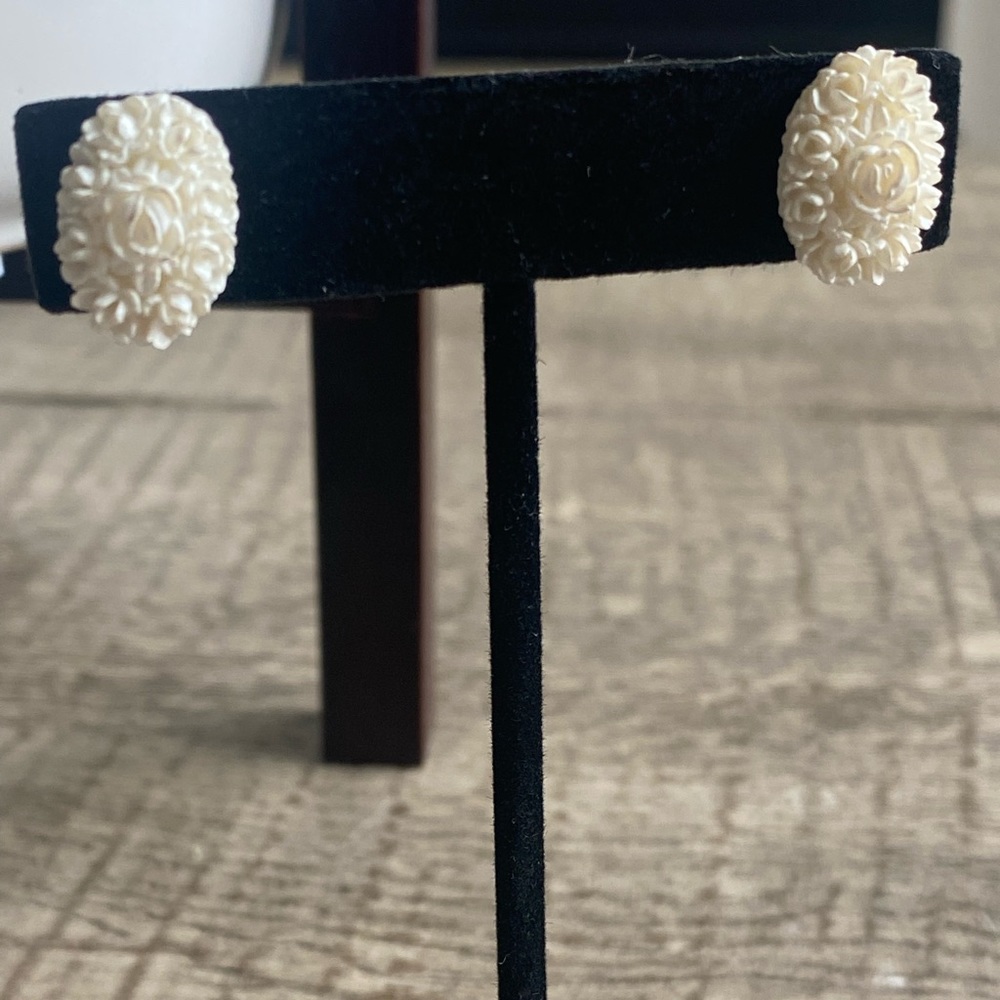 Vintage 50’s featherweights cream carved celluloid earrings. Pierced ears